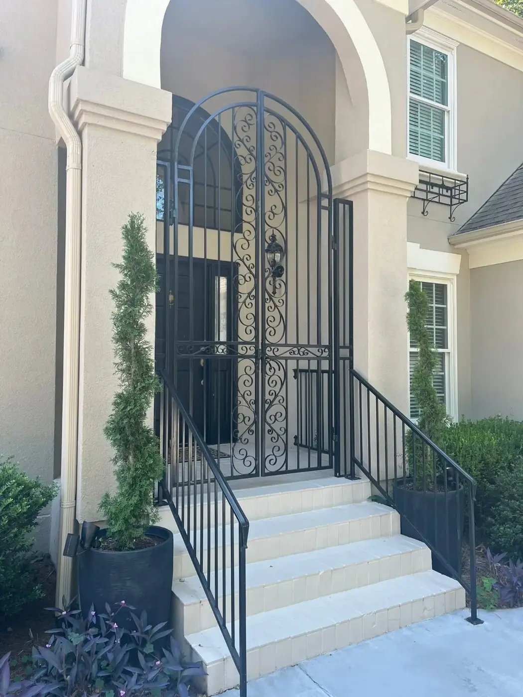 Custom ornamental arched entry gate at a residential entrance